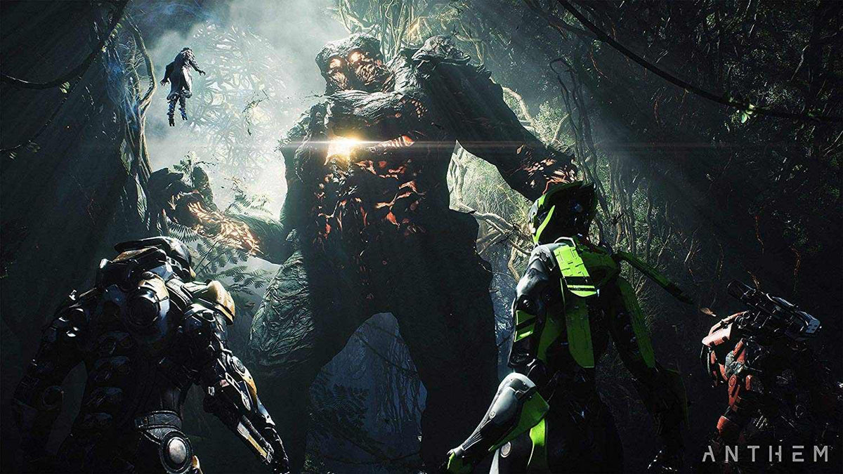Action scene from Anthem PS4 showing four futuristic armored exosuit pilots confronting a massive glowing rock-like monster in a dense forest environment.