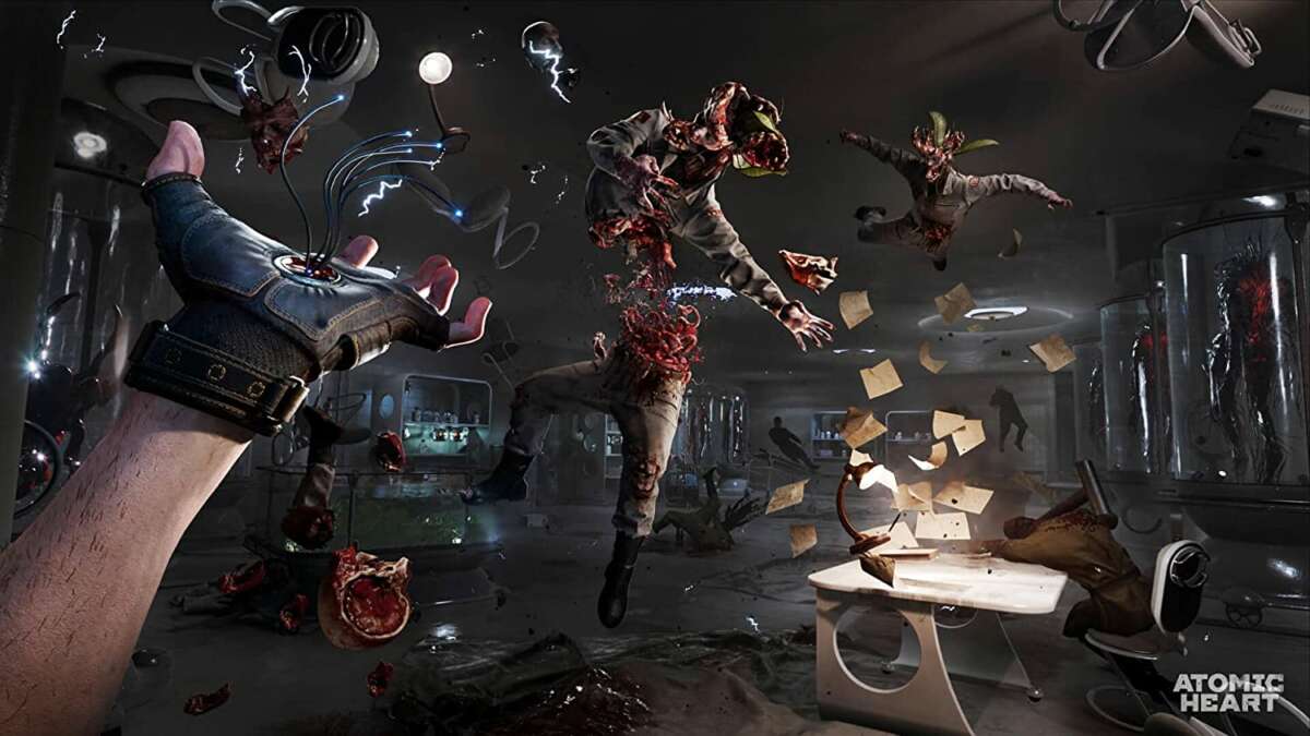 First-person view video game scene showing a gloved hand emitting electric sparks attacking monstrous humanoid creatures in a dark, chaotic laboratory setting titled Atomic Heart PS4.