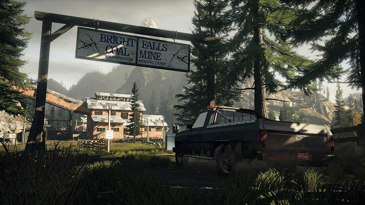 Gameplay scene from Alan Wake Remastered showing a dark pickup truck near a worn Bright Falls Coal Mine sign surrounded by trees and mountains.