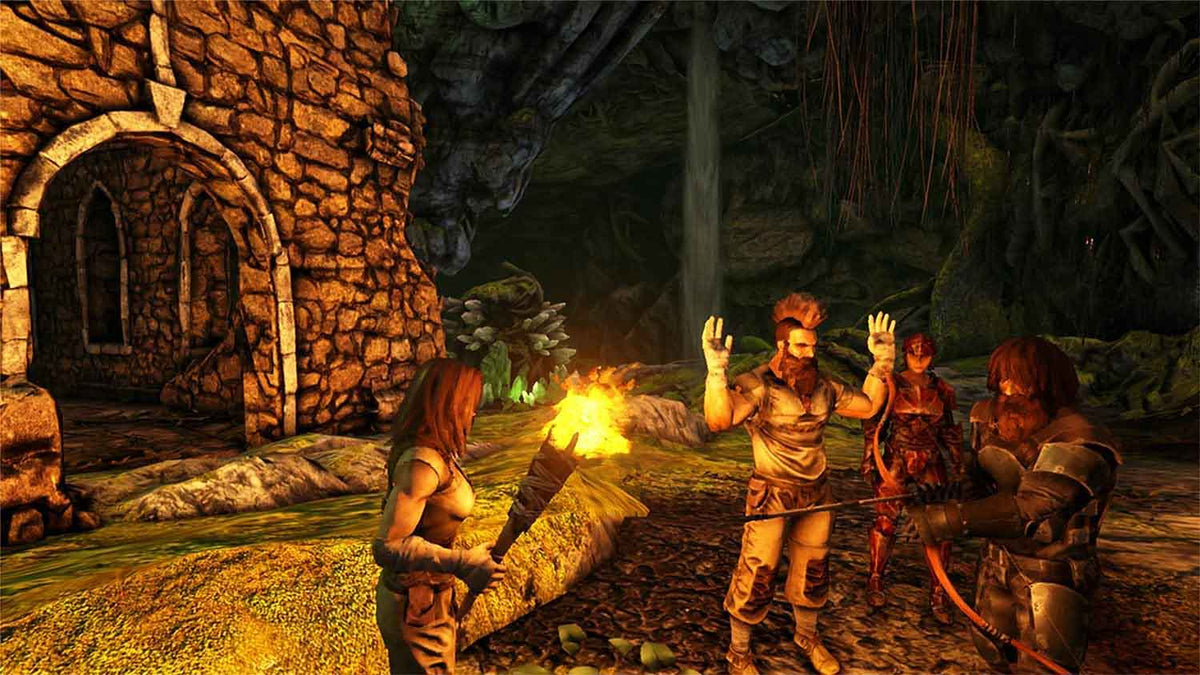 Screenshot from ARK: Survival Evolved showing characters with primitive gear and torches in a cave setting near a stone structure, highlighting the game's prehistoric survival theme.