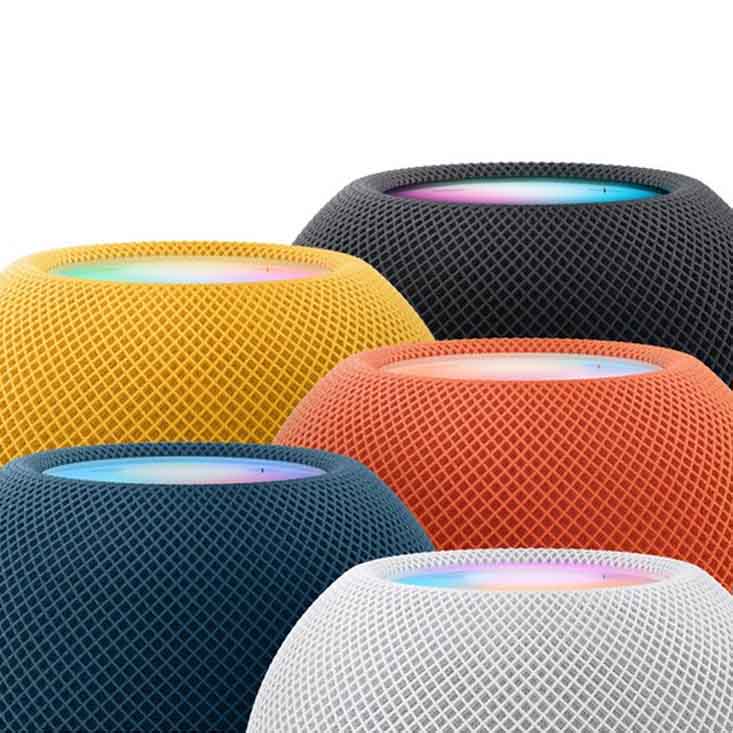 Apple HomePod Mini speakers in white, yellow, orange, blue, and black with mesh fabric and glowing touch surfaces.